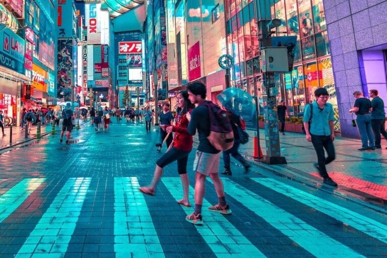 Young man helping a woman cross the street in Japan