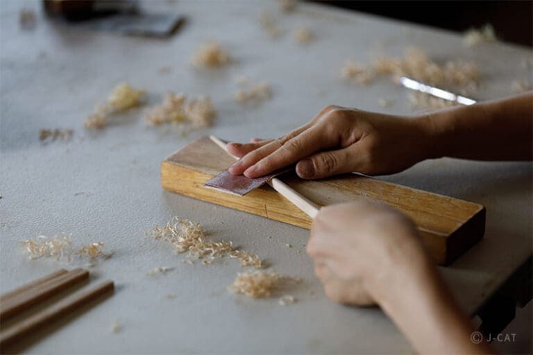Hands of a person making chopstick in a chopstick-making workshop in Tokyo