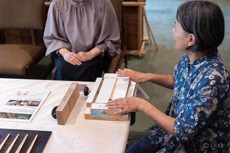 Two people talking during a bamboo chopstick-making workshop in Kyoto