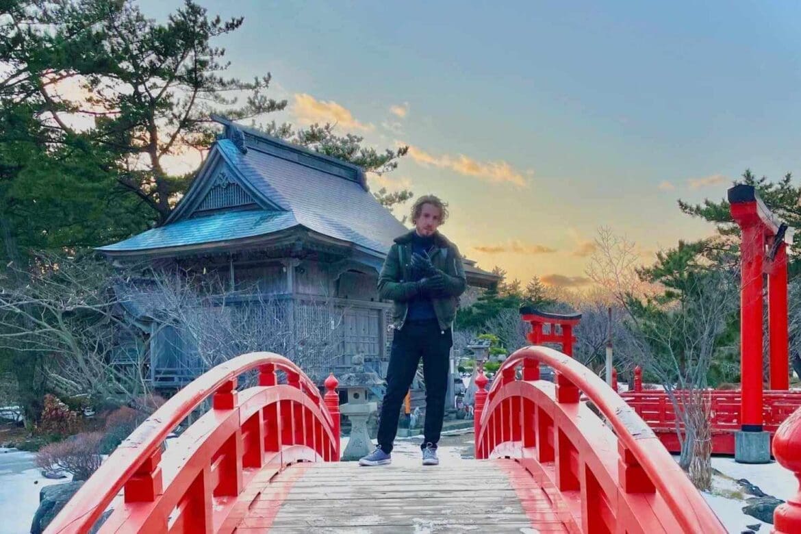 YavaJapan standing on a red bridge when traveling in Japan in Aomori