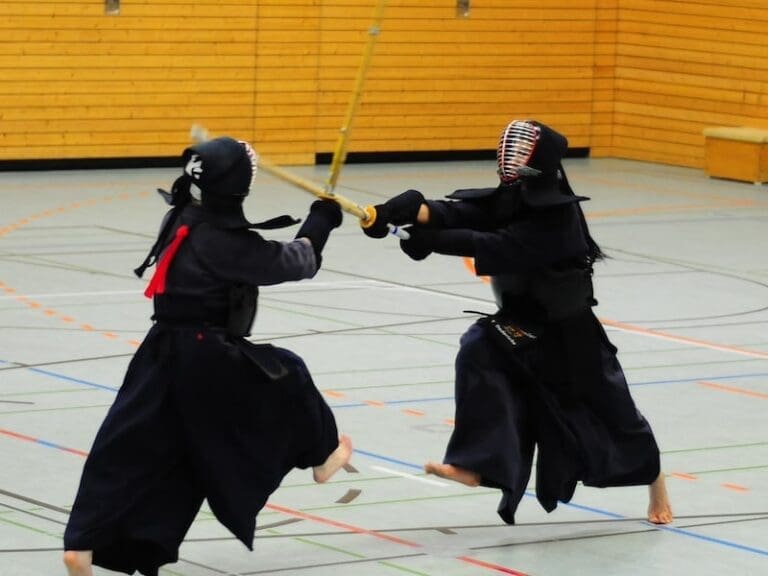 two kendo practitioners fighting in a gymnasium
