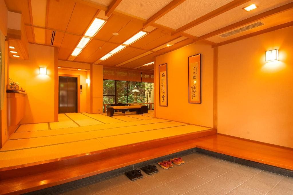 Tatami room with low table, shoji screens, and garden view at Ichinoyu Katei