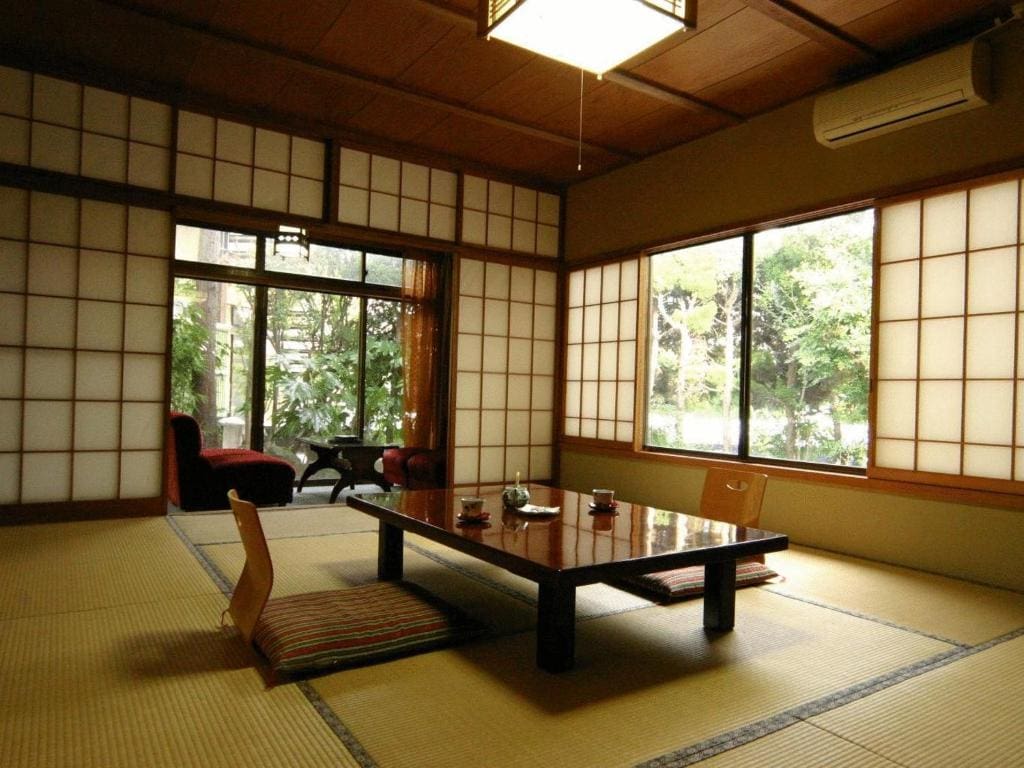 Traditional tatami room with low table and garden view at Kamesei Ryokan