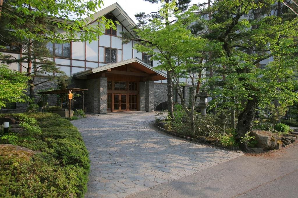 Exterior of Kanbayashi Hotel Senjukaku with stone path and garden