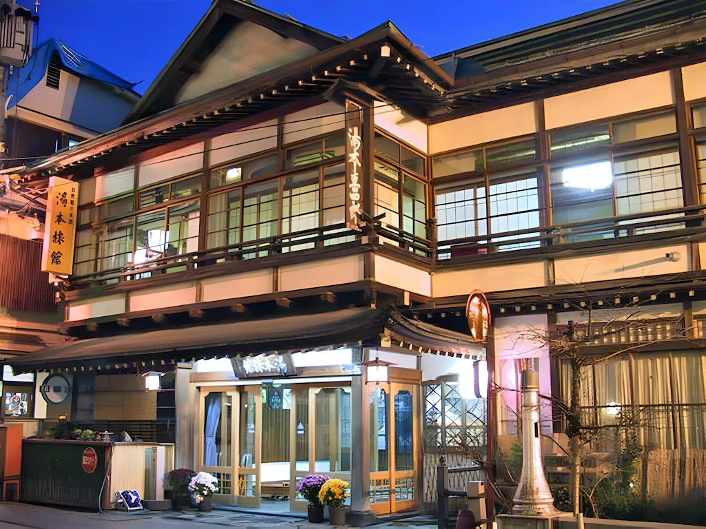 Exterior of Yumoto Ryokan in Shibu Onsen at night with lit entrance and wooden façade