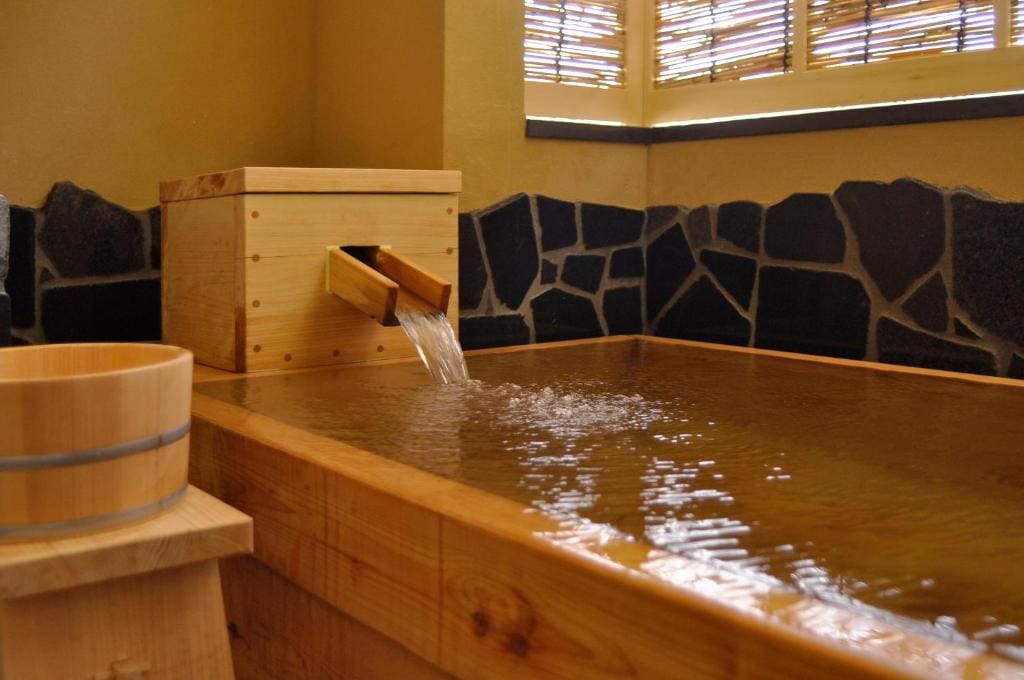 Indoor private wooden bath with flowing onsen water at Wafu-no-Yado Masuya