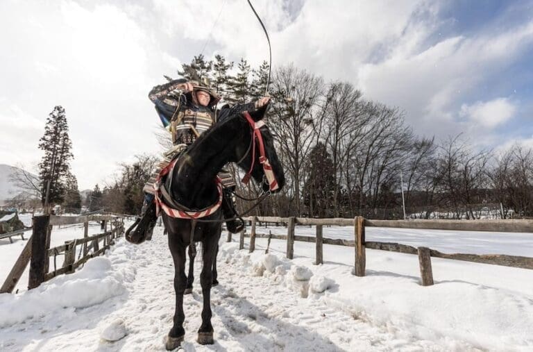 Samurai on a horse in the snow shooting an arrow to show yabusame, horseback archery