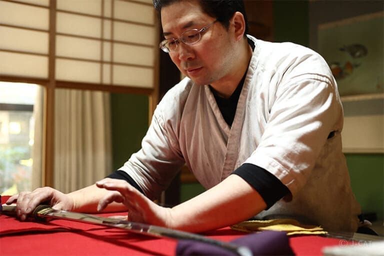 Japanese master swordsmithing examining a katana