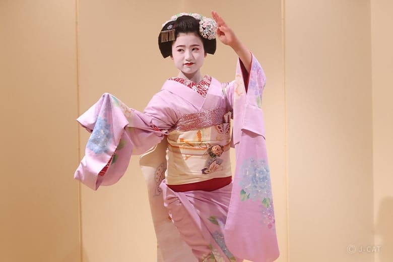 Maiko performing a traditional dance at geisha dinner in Kyoto