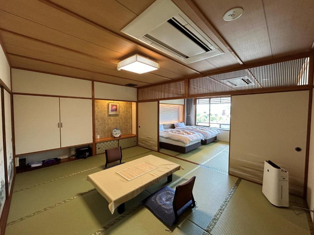 Traditional Japanese-style room at Jukeiso with tatami flooring, low table, and two single beds in a separate sleeping area.
