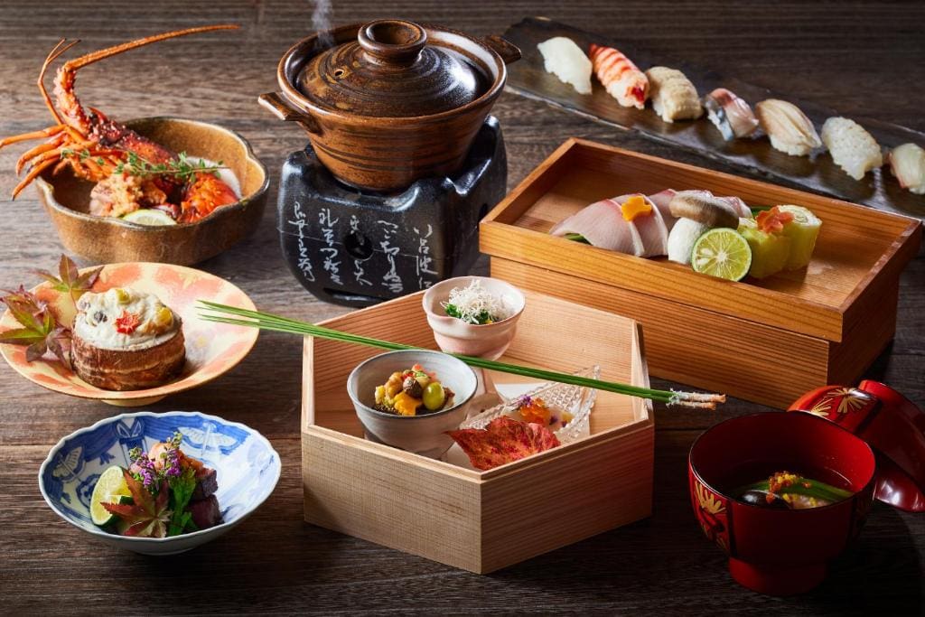 Multi-course kaiseki dinner set at Kurayado Iroha, including sushi, soup, vegetables, grilled seafood, and various side dishes.
