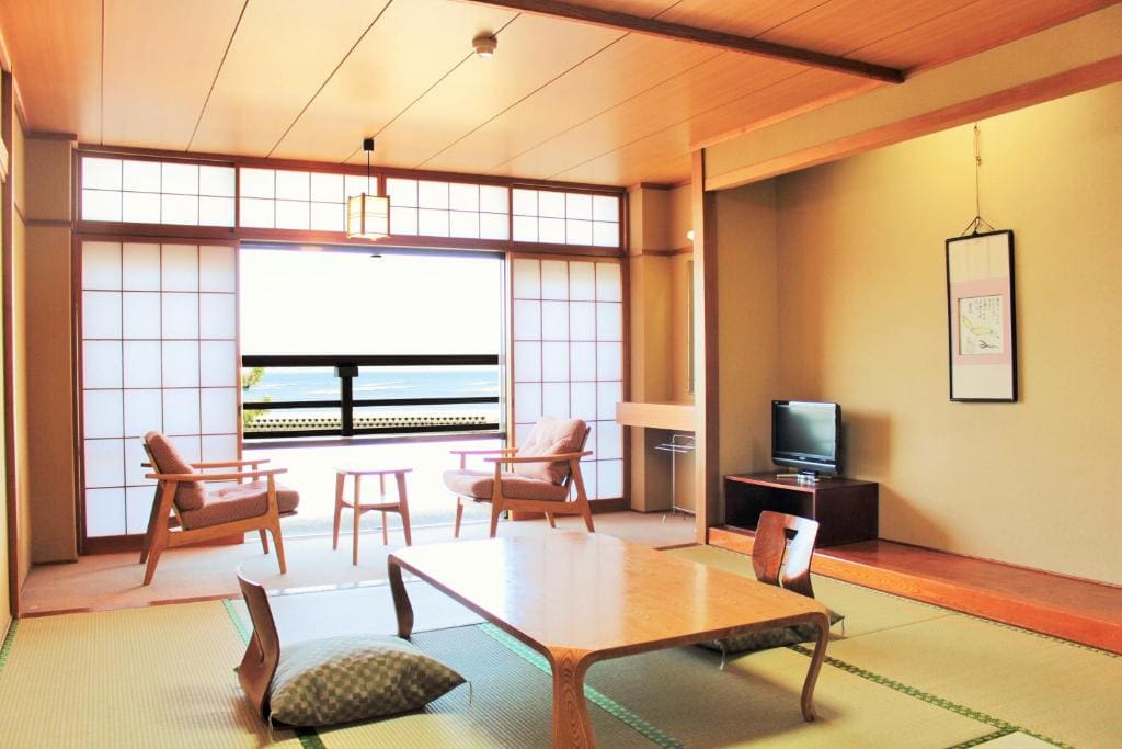 Bright Japanese-style guest room at Miyajima Seaside Hotel with tatami flooring, low table, and a seating area facing the ocean.