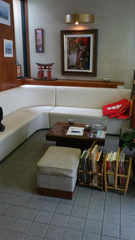 Waiting area inside Yamaichi Bekkan with white couches, a bookshelf, and a framed artwork on the wall.