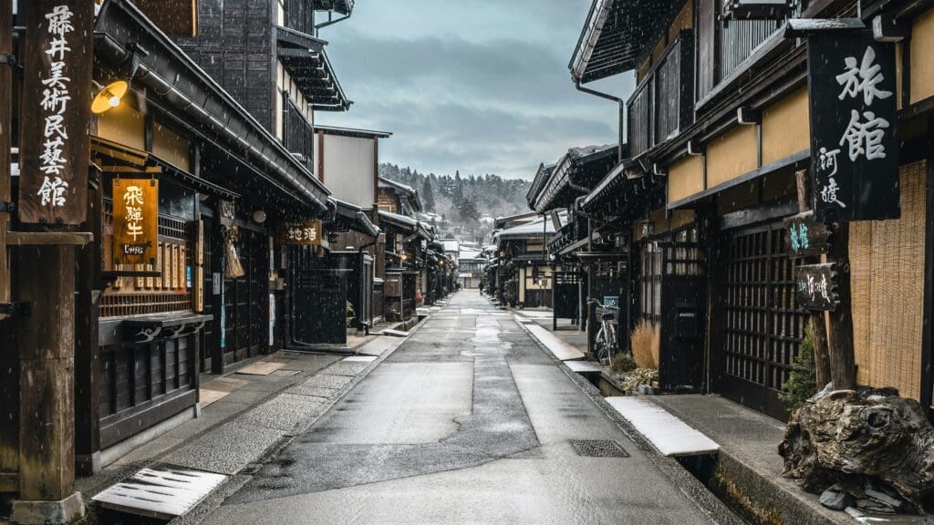 Traditional wooden buildings along a snow-dusted street in Takayama, Japan