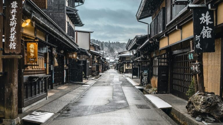 Traditional wooden buildings along a snow-dusted street in Takayama, Japan