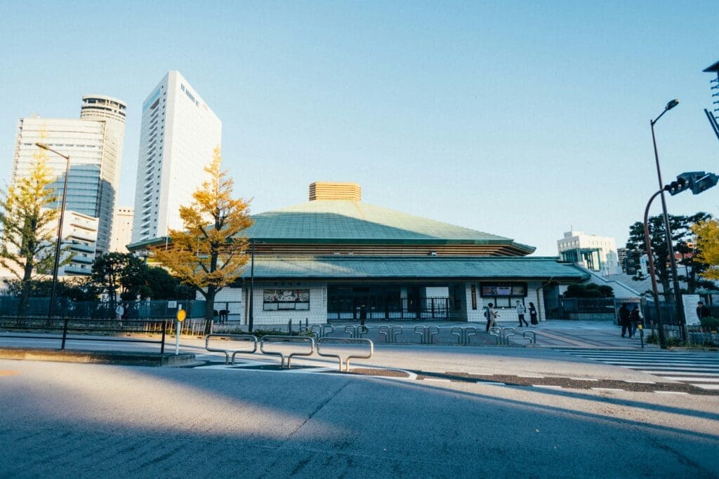 Ryogoku Kokugikan sumo arena exterior with green roof and autumn trees