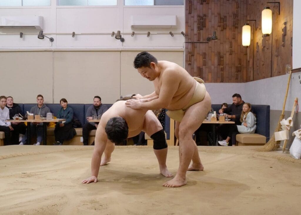 Sumo wrestlers demonstrating a bout in a restaurant ring during a Viator yokozuna tonkatsu sumo lunch show