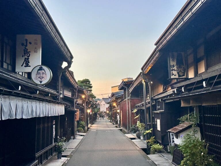 Wooden Edo-period shops lining a narrow street in Takayama Sanmachi at dusk