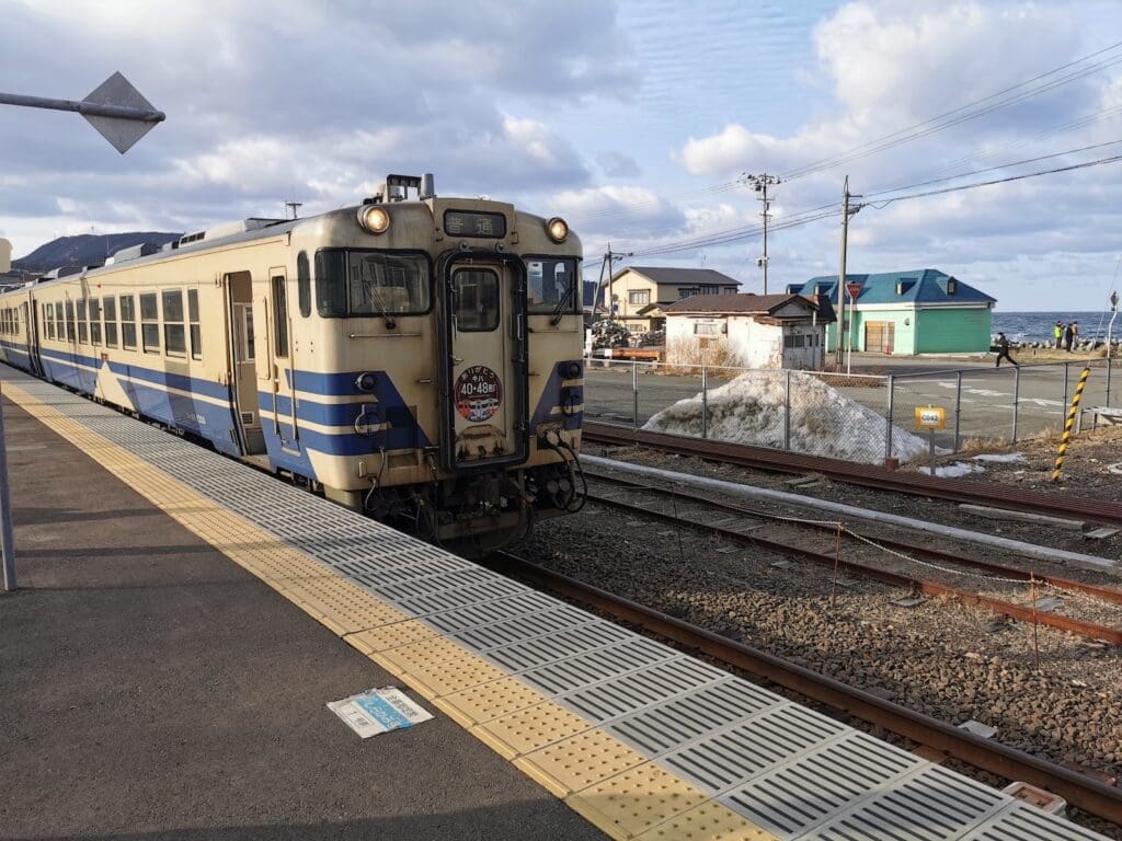Local train at Fukaura Station on the JR Gono Line in Aomori, with the Sea of Japan in the background