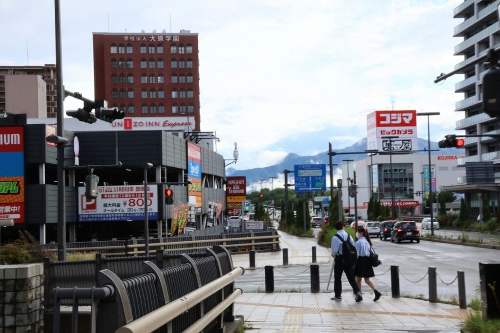 Morioka city street with shops, pedestrians, and mountains in the background